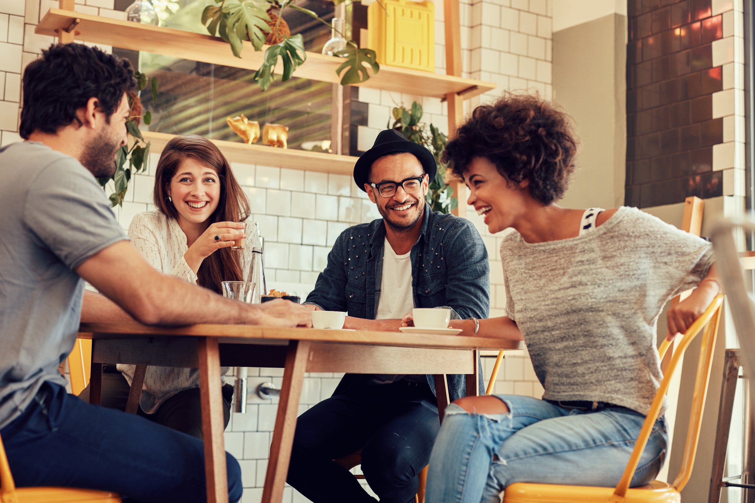 Eine Gruppe junger Menschen macht Pause im Bistro und trinkt einen Kaffee