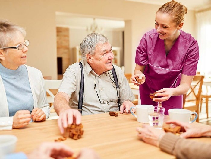 Senioren unterhalten sich mit einer Fachkraft der Pflege über Verpflegungsempfehlungen für ihre Ernährung