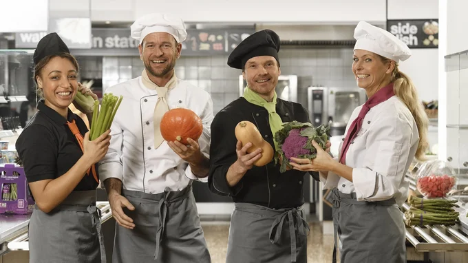 Küchenteam von apetito catering mit frischem Gemüse freut sich auf die Verpflegung der Gäste und Mitarbeiter 