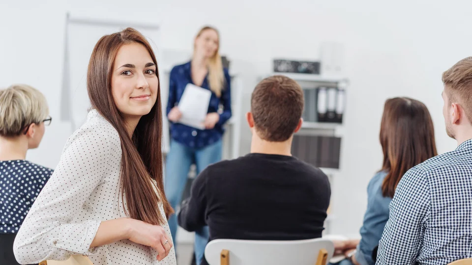 Wissbegierige Mitarbeiterin nimmt an einem Seminar zu Weiterbildung teil