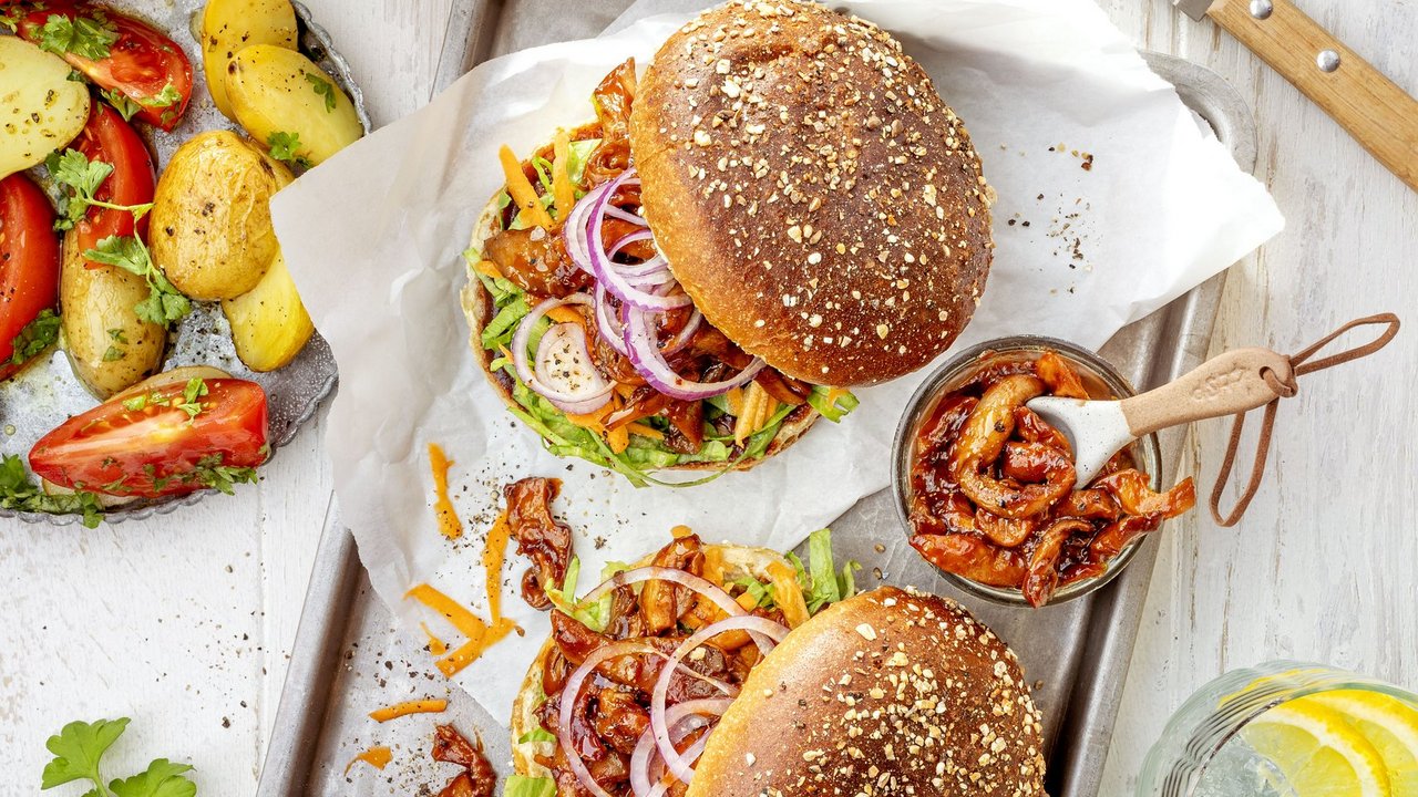 BBQ Burger aus Austernpilzen belegt mit Zwiebeln, Champignons und Salat