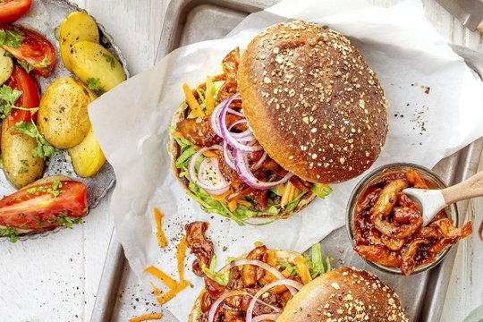 BBQ Burger aus Austernpilzen belegt mit Zwiebeln, Champignons und Salat