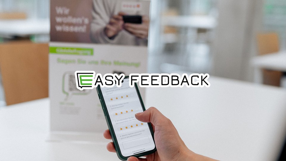 Anwendung Easy Feedback, im Hintergrund eine schwarzes Handy mit einer Bewertungsskala 